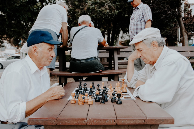 Pensionari joacă șah în parc