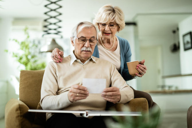 Cuplu de pensionari se uită la documente