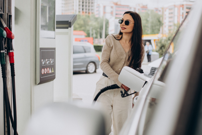 O femeie alimentează la o benzinărie