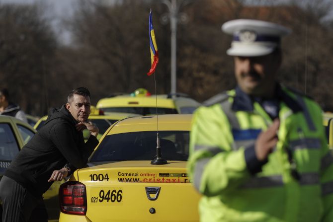 Un taximetrist privește un polițist care dirijează traficul / Foto: Octav Ganea / Inquam Photos